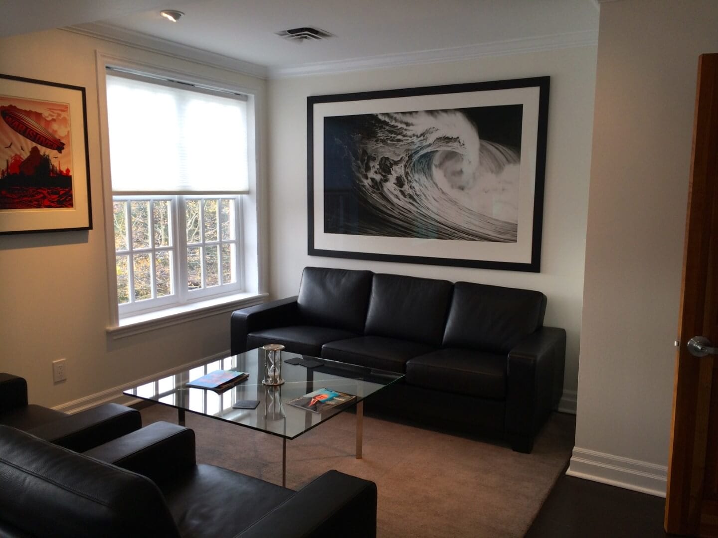 Modern office interior with black leather couches and wave artwork, available at Chelsea Art Group - New York City top trusted art advisers in conceptual, drawing, painting, photography and sculpture.